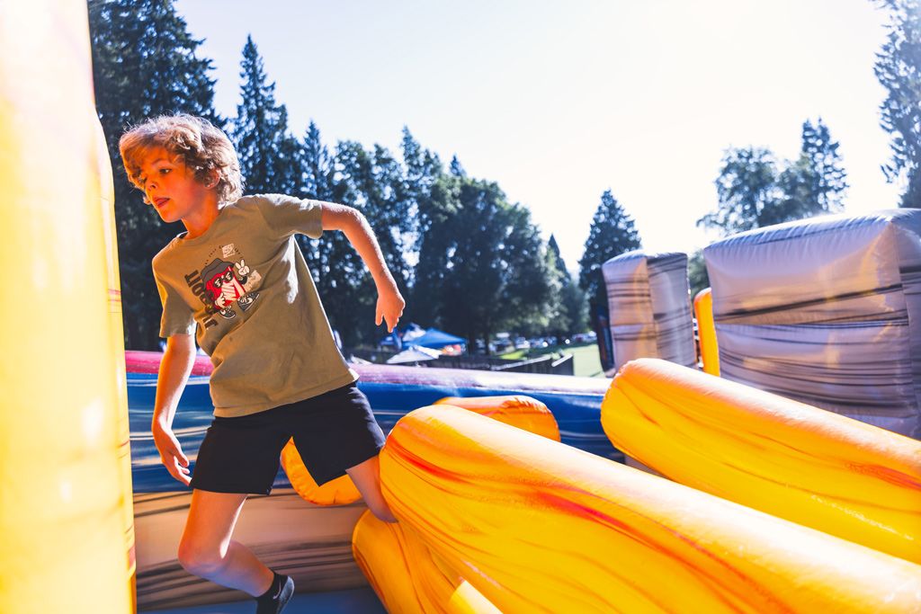 A kid playing in the inflatable bounce house at a past Cool August Nights