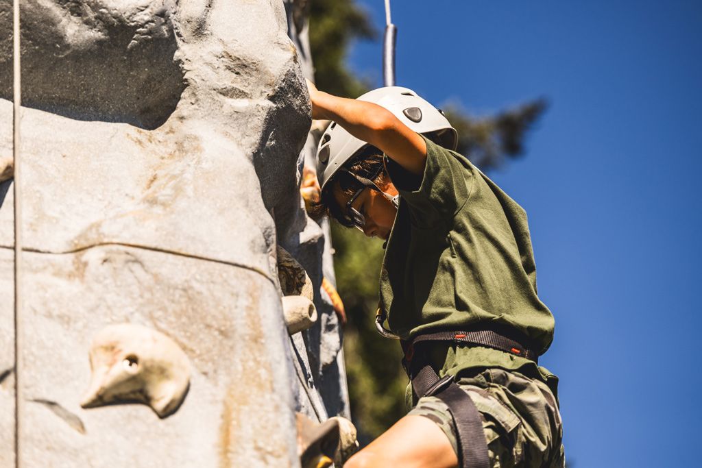 A kid scaling the rock climbing wall at a past Cool August Nights