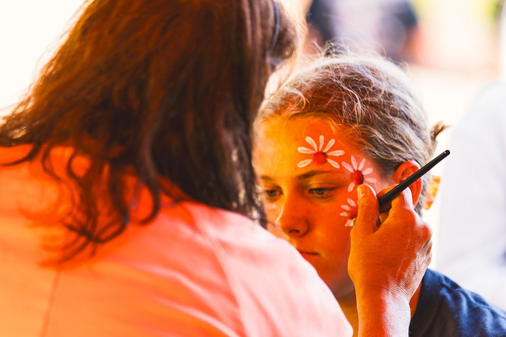 A kid getting their face painted at a past Cool August Nights
